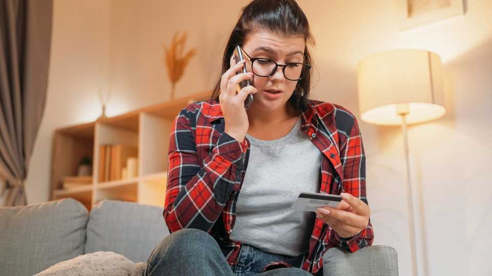 woman providing credit card information over the phone to a potential fraudster