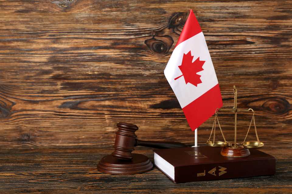 justice scales with the canadian flag in the background