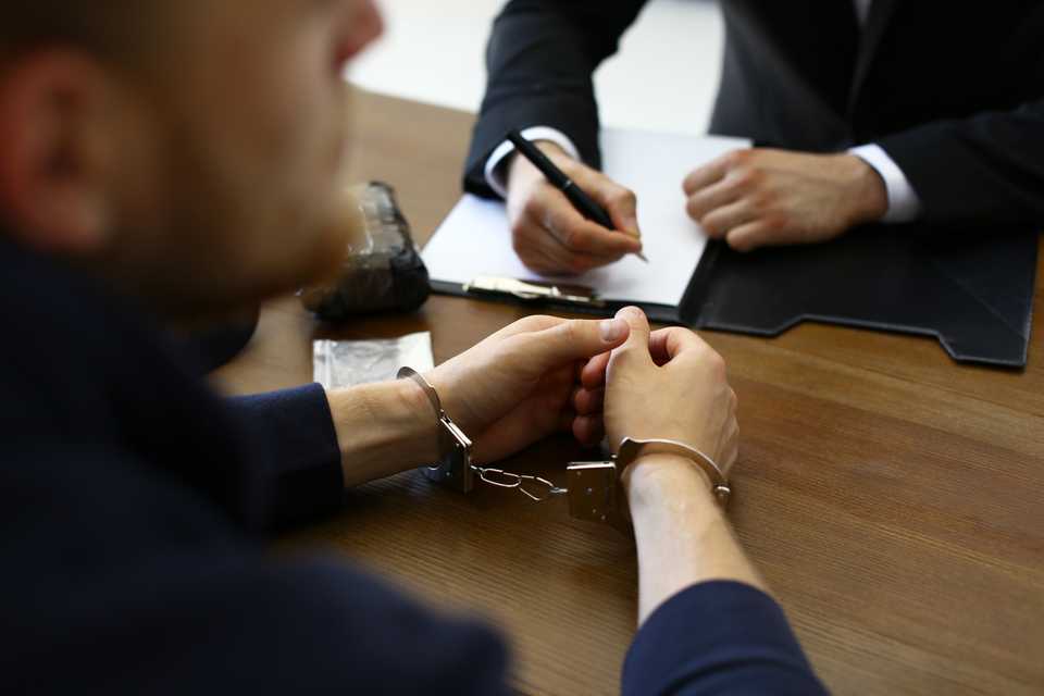 man being interrogated by a police officer for credit card fraud